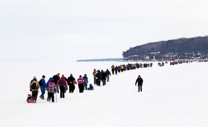 Sightseers trek across a frozen expanse of Lake Superior to the sea caves of the Apostle Islands National Lakeshore